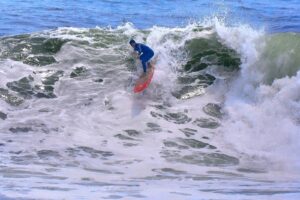 Surfista bajando una ola en la playa Punta Rocas, en Punta Hermosa, Lima