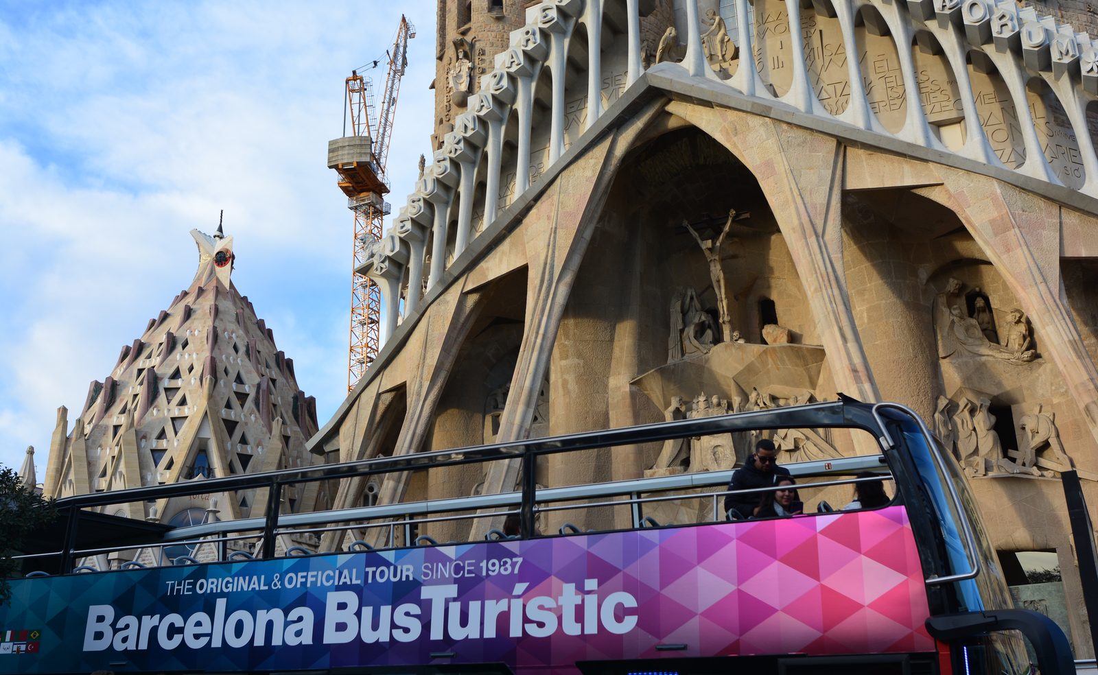 Foto: Joe Mabel — CC BY-SA 4.0 (Wikimedia Commons), https://commons.wikimedia.org/wiki/File:Tourist_bus_in_front_of_Sagrada_Familia.jpg